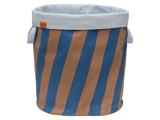 En opbevaringskurv af stof med lodrette blå og brune striber, hvid kant øverst og to håndtag i siden.