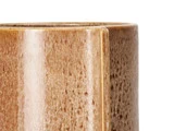 Nærbillede af en cylindrisk, brun beholder af keramik eller træ med en blank, struktureret overflade mod en hvid baggrund.