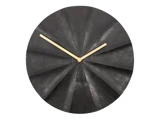 Et rundt, sort vægur med et struktureret, vifteformet mønster og tynde time- og minutvisere i guld på en hvid baggrund.