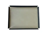 Et lukket beige laptop-sleeve ligger inde i en åben sort kasse på en hvid baggrund.