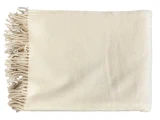 Et pænt foldet cremefarvet tæppe med frynsede kanter på den ene side, vist på en hvid baggrund.