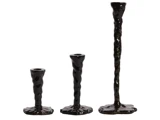 Tre sorte, uregelmæssigt formede lysestager i forskellige højder er arrangeret side om side mod en hvid baggrund.