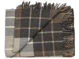 Et foldet, frynset plaid-tæppe i brune, beige og cremefarvede nuancer med et ternet mønster.