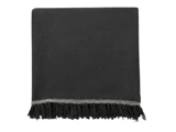 Et mørkegråt tekstureret tæppe med frynser og en dekorativ flettet kant langs den ene kant, vist på en hvid baggrund.