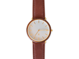 Et minimalistisk armbåndsur med hvid urskive, guldmarkører og en brun læderrem, vist fra oven.