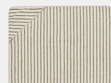 Et rektangulært beige håndklæde med tynde, ujævne grønne lodrette striber. Det øverste venstre hjørne er foldet og viser bagsiden med diagonale grønne striber.