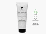 En hvid tube med grums raw espresso face scrub + mask med sort tekst, prikket design og ikoner, der indikerer, at den er allergivenlig og fremstillet i Danmark.