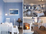 Fire billeder af en hyggelig restaurant med blå vægge, hvide duge, trægulve, hvide stole, vægkunst, et tændt stearinlys og en brændende pejs, der skaber en varm og indbydende atmosfære.