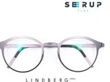 Et par runde, sølvfarvede briller med tyndt stel er centreret på en hvid baggrund. Ordene SEERUP FLEX og LINDBERG står over og under brillerne.