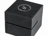 En sort, firkantet urkasse med logoet Schmidt Watches SW Est. 2018 trykt i hvidt på låget.