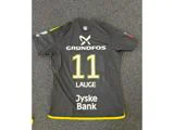 En sort sportstrøje med gule kanter, hvor der på ryggen stod navnet Lauge, nummer 11 samt sponsorerne Grundfos og Jyske Bank, lå fladt ud på et gråt tæppe.