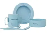 Lyseblåt børneservice med tallerken, skål, kop med hank og to skeer, hver mærket med ord som MINI, DARLING og LOVE.
