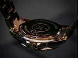 Nærbillede af bagsiden af et armbåndsur med indgraveringer, herunder All Stainless Steel, 10ATM Water Resistant og Limited Edition. Metalarmbåndet er delvist synligt.