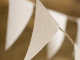 Nærbillede af flag i beige stof, der hænger på en snor, med en sløret brun baggrund.