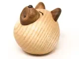 En rund træfigur, der ligner et kattehoved, med brune ører og næse og minimale ansigtstræk på en lys træstruktureret overflade.