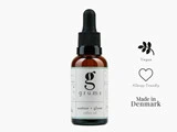 En brun dråbeflaske mærket grums restore + glow coffee oil med ikoner, der angiver, at den er vegansk, allergivenlig og fremstillet i Danmark.