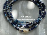 Perlearmbånd viklet fire gange med blå, sorte, sølv- og guldperler og en enkelt ferskvandsperle; teksten lyder "4x wrap med ferskvandsperle.".