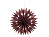 En mørk rødbrun, stjerneformet papirdekoration med spidse kanter og diamantformede udskæringer, der hænger i en snor mod en hvid baggrund.