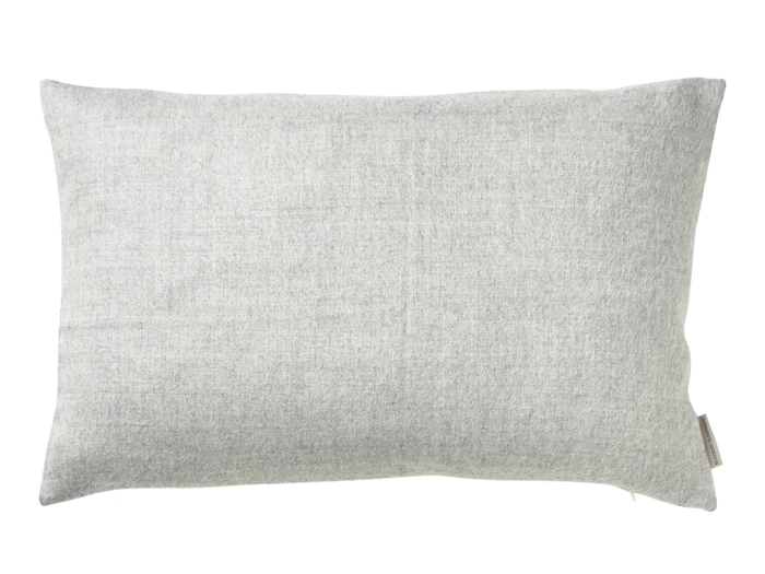 En rektangulær lysegrå pude med et blødt, struktureret stof, vist mod en hvid baggrund.