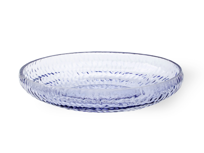 En gennemsigtig, rund, lav glasskål med en struktureret overflade og et let blåt skær, placeret på en hvid baggrund.