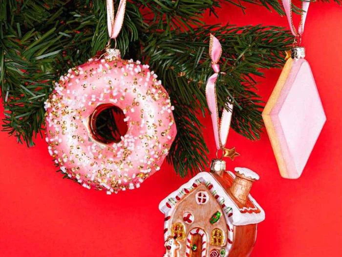 En donut og et peberkagehus som pynt på et træ.