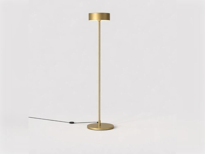 Minimalistisk gulvlampe i guld med en slank stamme samt en cirkulær fod og lampeskærm.