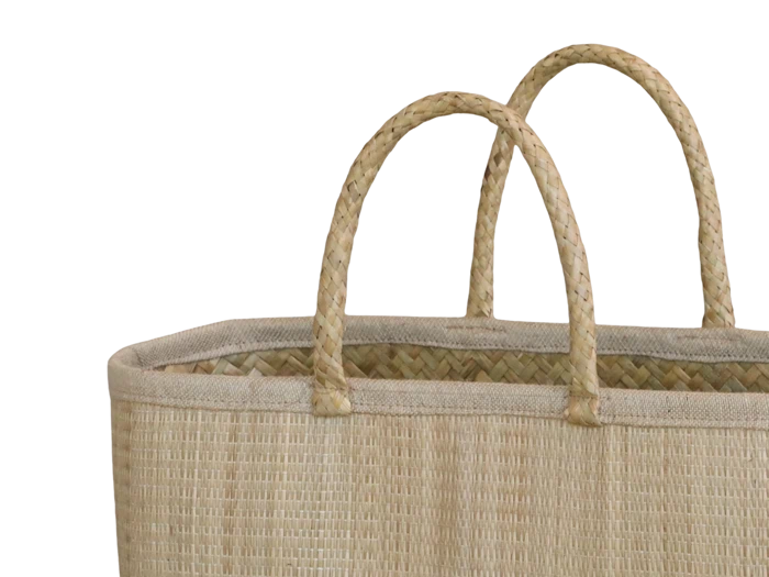 Nærbillede af en flettet halmkurv med to flettede hanke mod en almindelig hvid baggrund.