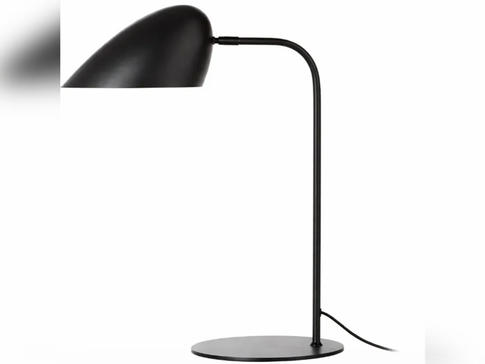 En moderne sort bordlampe med en buet hals og en rund fod, udstyret med en kuppelformet lampeskærm, der er vinklet nedad.