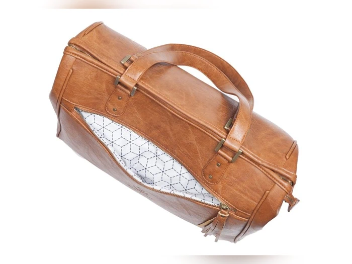 En brun duffelbag i læder med to hanke og en åben lynlåslomme foran, som afslører et hvidt inderfor med et geometrisk mønster.