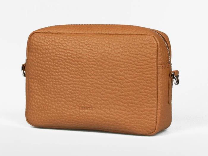 En lille rektangulær, brun læderpung med lynlås på toppen, stenet tekstur og metalstropper på hver side til en rem.