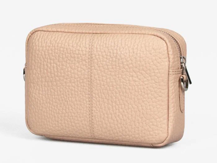En lille, rektangulær crossbody-taske i lys beige læder med struktureret overflade og lynlåslukning i toppen.