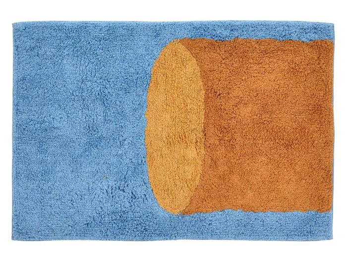 Et rektangulært blåt tæppe med en brun cylindrisk form i højre side, der ligner en 3D-stamme eller -tunnel.