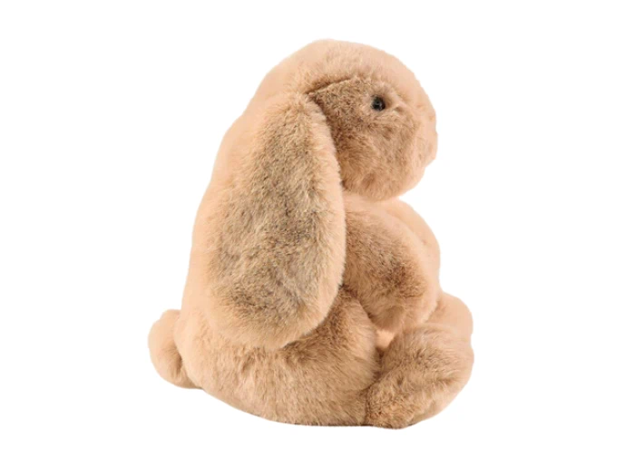 En blød, lysebrun kanin i plys med hængeører sidder oprejst med ansigtet mod højre på en hvid baggrund.