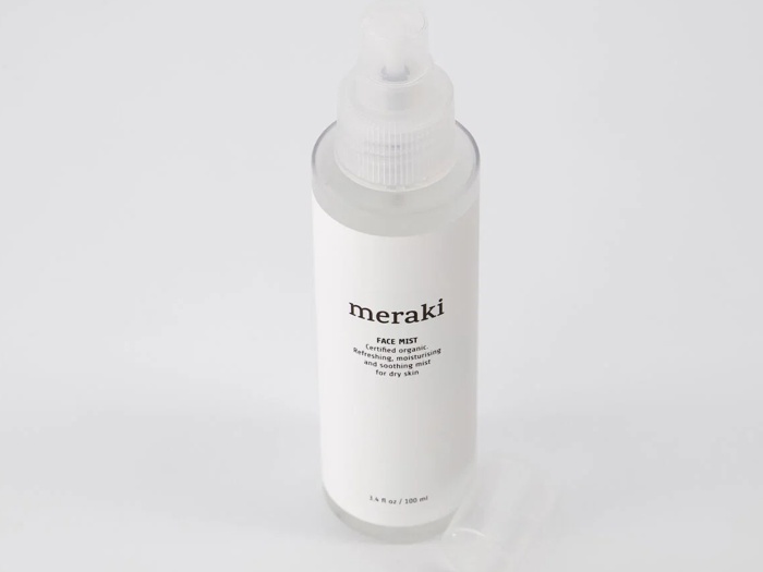 En sprayflaske i klar plast med påskriften meraki face mist for dry skin med en gennemsigtig hætte ved siden af på en hvid baggrund.