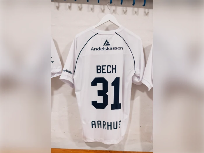 Hvid sportstrøje med navnet BECH, nummer 31 og AARHUS trykt på ryggen samt Andelskassen-logoet.