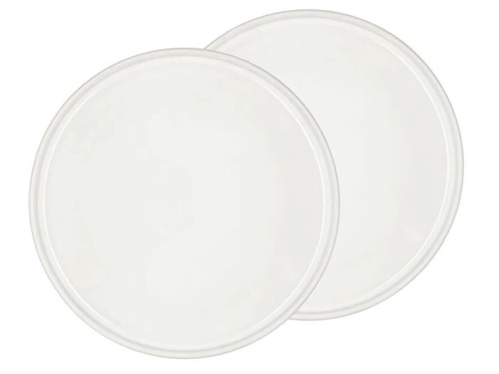 To almindelige, runde, hvide tallerkener overlapper hinanden på en hvid baggrund.