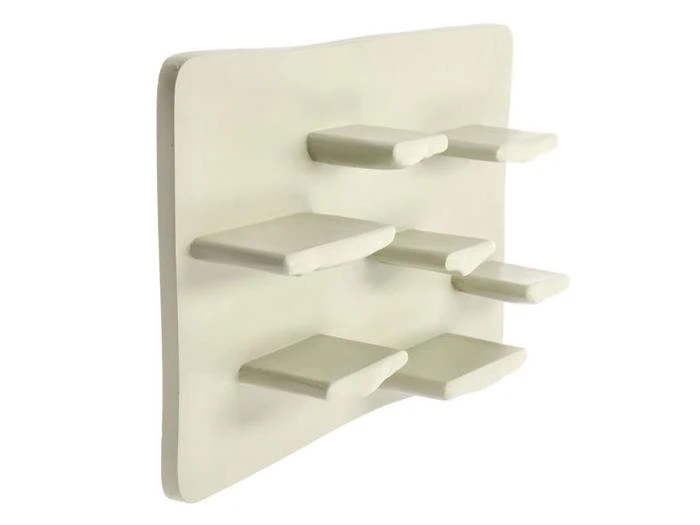 En moderne, abstrakt hvid væghylde med otte rektangulære platforme med ujævne mellemrum fastgjort til en buet bagside.