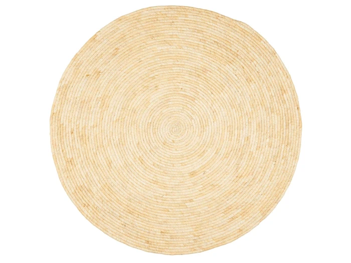Et rundt, lysbeige vævet tæppe med koncentriske cirkelmønstre, set ovenfra på en hvid baggrund.