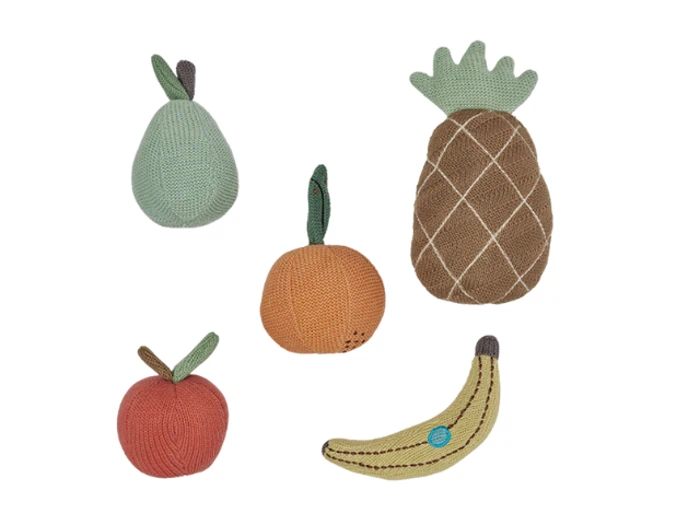 Fem strikkede stykker legetøj formet som frugter: en pære, et æble, et græskar, en ananas og en banan, alle i bløde, dæmpede farver, arrangeret på en hvid baggrund.