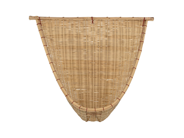 En stor, kegleformet flettet kurv lavet af lyse naturmaterialer med røde bånd, der fastgør kanten og siderne.