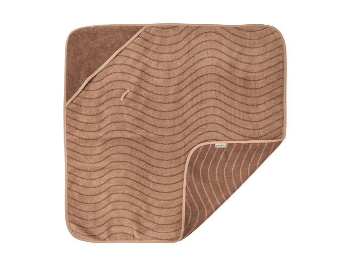 Et brunt, firkantet badehåndklæde med bølgelinjer og et hjørne, der er foldet om og afslører en ensfarvet brun underside og et lille stofmærke på kanten.