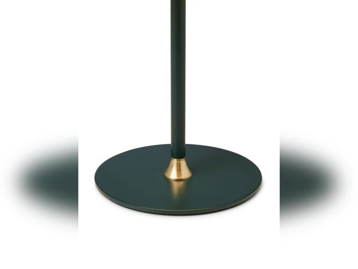 Et nærbillede af en lampe- eller standerfod med en rund, mørkegrøn platform med en guldaccent, hvor stangen møder foden, mod en hvid baggrund.