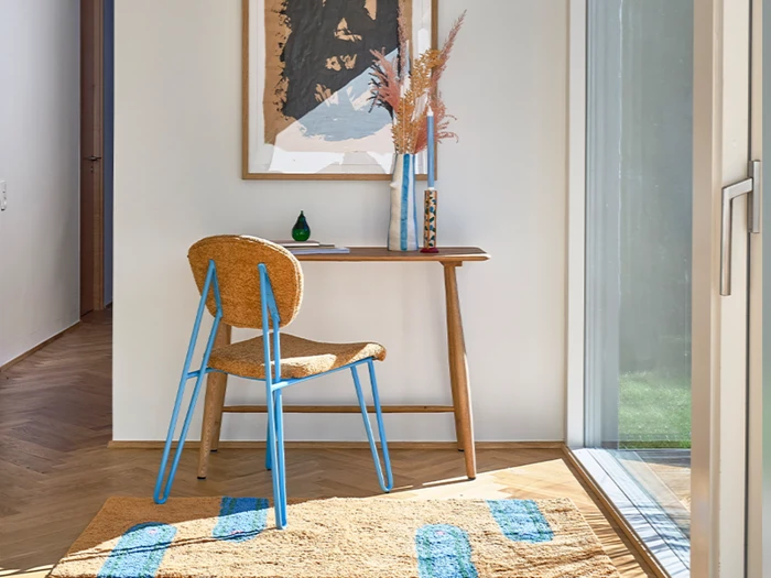 En stol og et bord med et maleri på væggen.