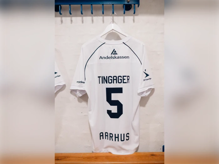 Hvid Aarhus-fodboldtrøje med navnet TINGAGER og nummer 5 i mørkeblå bogstaver på ryggen.