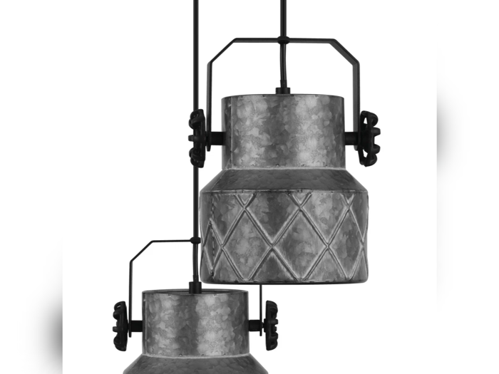 To metalpendler i industriel stil med cylindriske kroppe og diamantmønstrede detaljer, ophængt i sorte stænger mod en hvid baggrund.