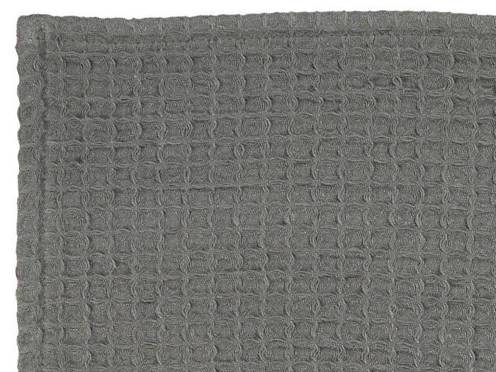 Et nærbillede af et gråt struktureret stof med vaffelvævet mønster.