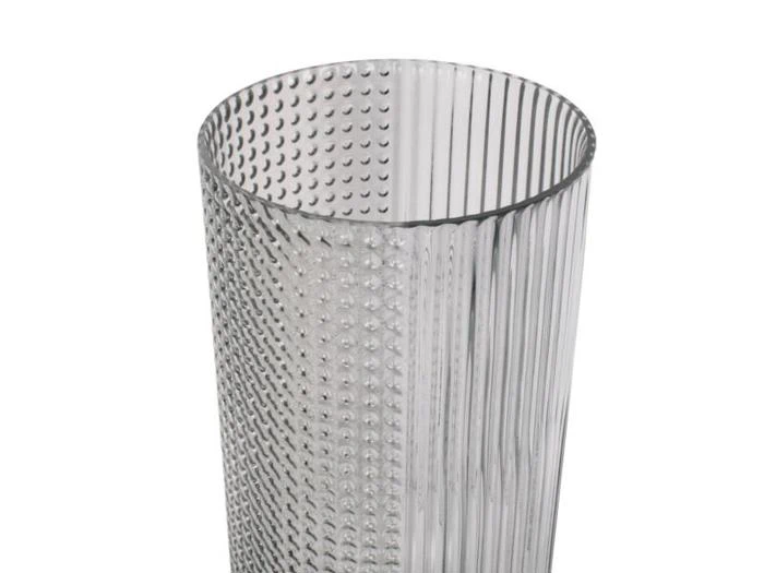 En klar glasbeholder, hvor den ene halvdel har lodrette riller og den anden halvdel er dækket af små, hævede prikker.