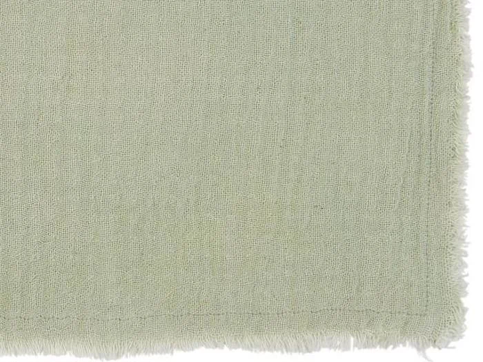 Et nærbillede af et lysegrønt struktureret stof med flossede kanter på højre og nederste side.
