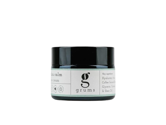 En lille glaskrukke med grums hudplejecreme med sort låg og hvid etiket med grums-logo og produktinformation.