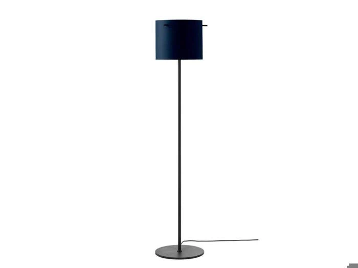 En moderne gulvlampe med en slank sort fod og en cylindrisk mørkeblå lampeskærm, der står på en rund base med en synlig netledning.